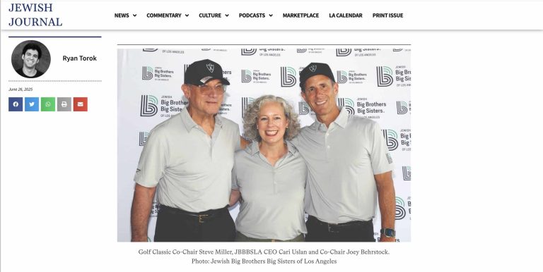 Three adults in matching light gray polo shirts and black caps stand together smiling in front of a step-and-repeat banner for Big Brothers Big Sisters of Los Angeles.